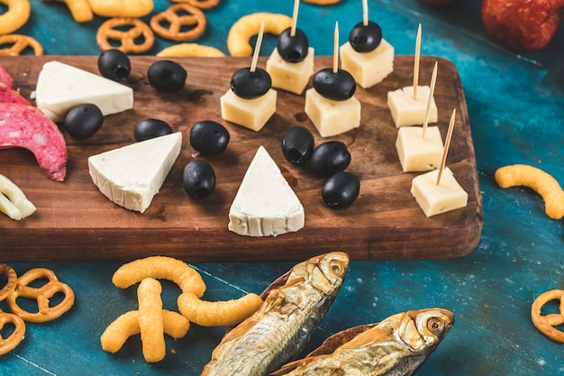 Crackers with smoked fish and cheese on blue background