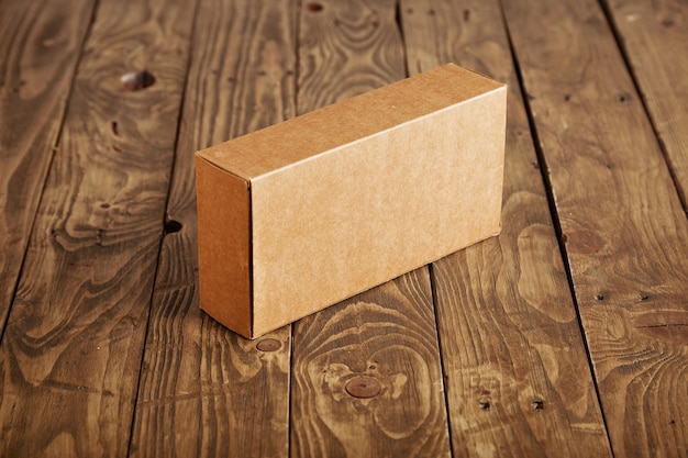 Free photo craft cardboard package box presented on stressed brushed wooden table