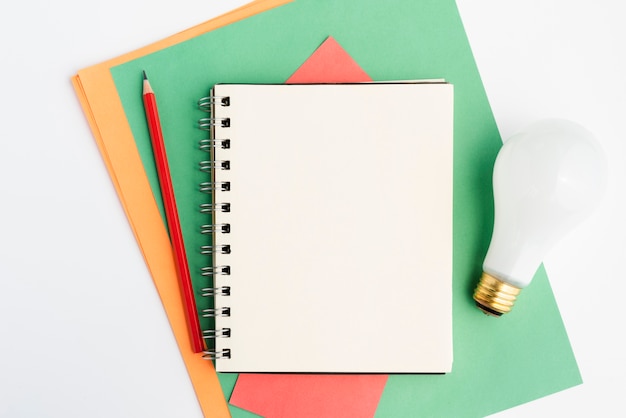 Craft stationery and white light bulb over white surface