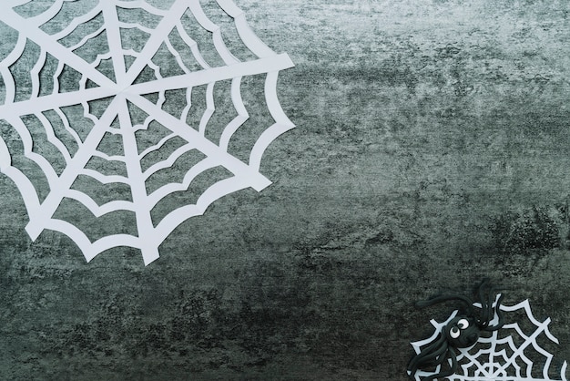 Free photo crafted web and toy spider on grey background