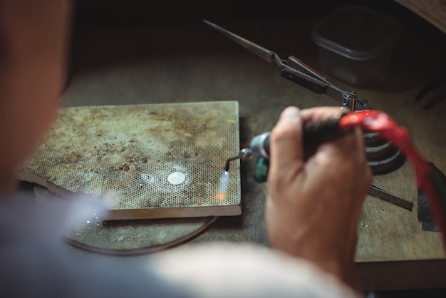 Free photo craftswoman using blow torch in workshop