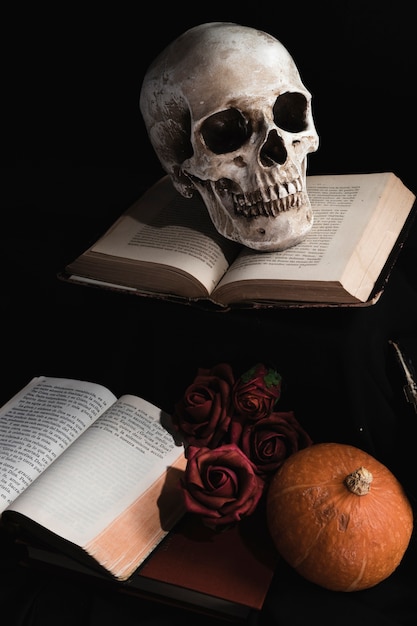 Cranium on books with roses and pumpkin