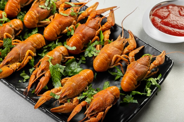 Free photo crawfish with herbs on black plate