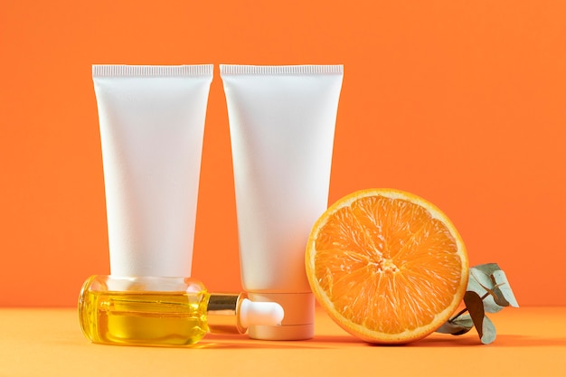 Free photo cream containers with orange background