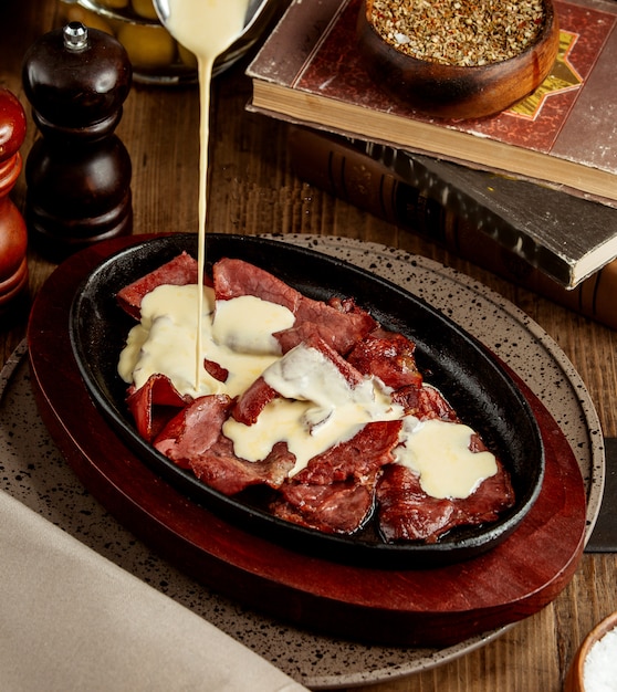 Free Photo cream is being poured on top of the raw cooked meat slices