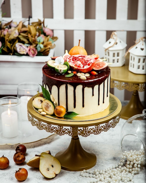 Creamy cake topped with chocolate and multiple fruits