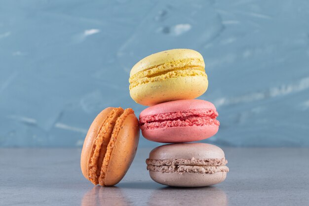 Creamy colorful sweet macaroons placed on marble surface