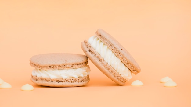 Creamy delicious macaroons on beige backdrop