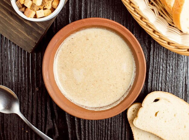 Creamy mushroom soup in pottery bowl with bread crackers. 