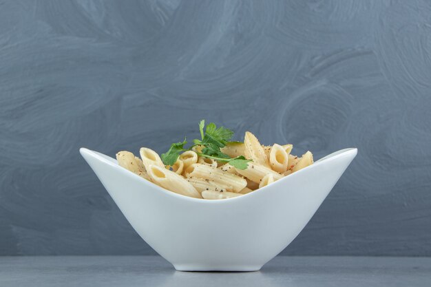 Creamy penne pasta in white bowl