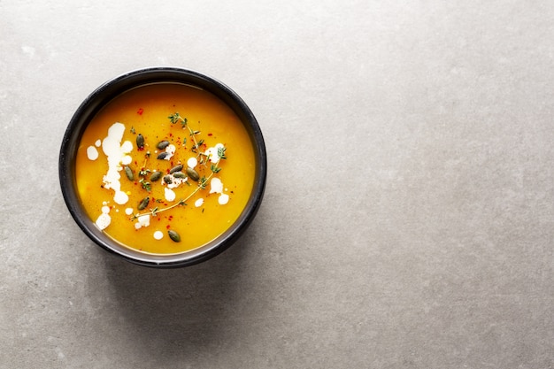 Creamy pumpkin soup served in bowl