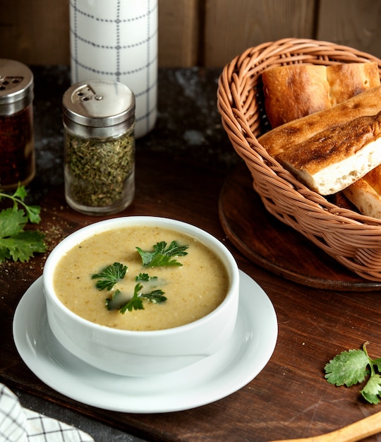 Creamy soup and basket with bread