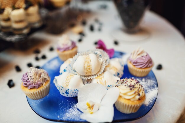 "Creamy yummy cupcakes on blue plate"