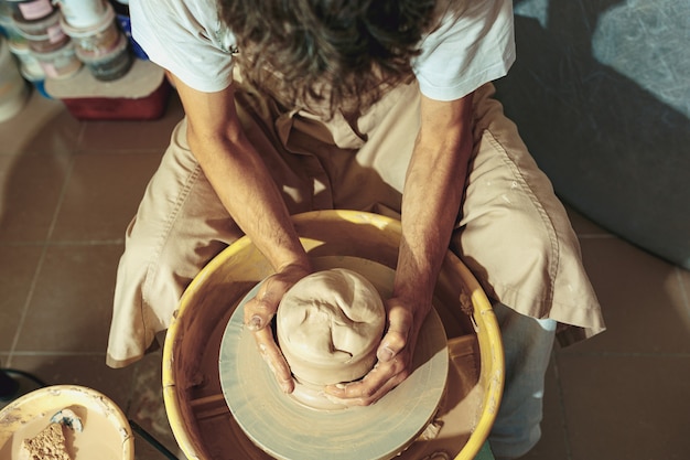 Free photo creating a jar or vase of white clay close-up. master crock.