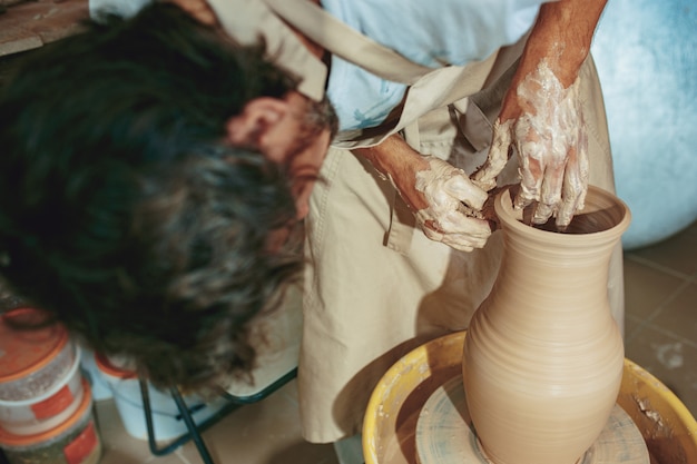 Free Photo creating a jar or vase of white clay close-up. master crock.