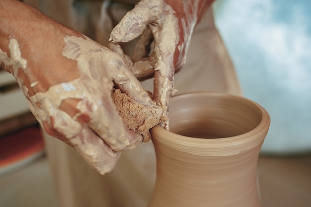 Free photo creating a jar or vase of white clay close-up