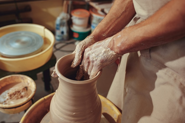 Creating a jar or vase of white clay close-up.