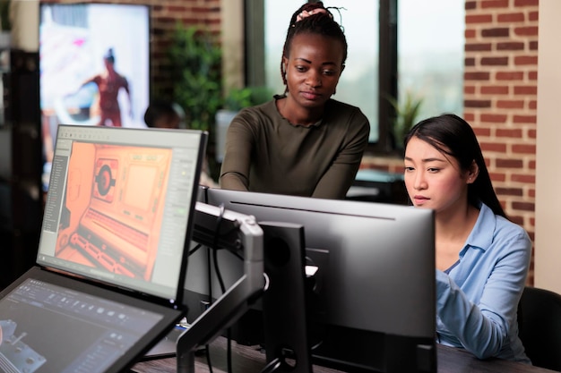 Free photo creative agency production department office workers brainstorming 3d project ideas. asian developer and african american colleague developing digital art using modelling software.