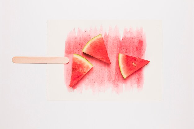 Creative composition of popsicle from ripe watermelon on stick