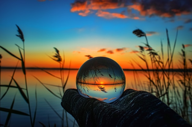 Free photo creative crystal lens ball photography of a lake with greenery around at dawn