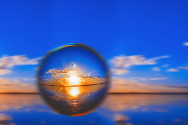 Free Photo creative lens ball photography of the sunlight on the horizon with clouds around in the blue sky