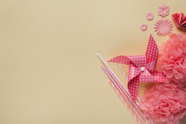 Creative pinwheel; paper flower and straw over beige surface