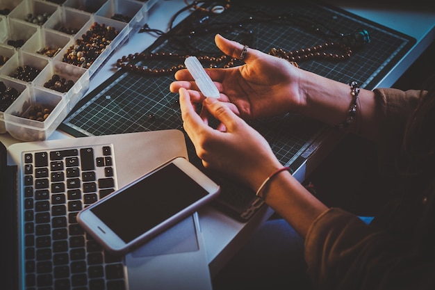 Free Photo creative student is holding crystal quartz in hands while sitting at her workplace.