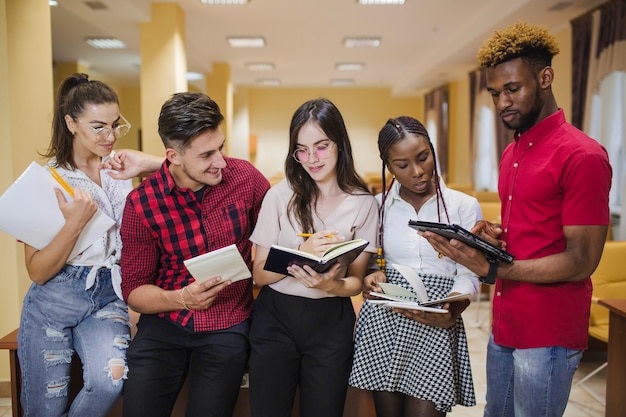 Creative students with books and gadgets