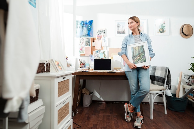 Free photo creative woman holding artwork