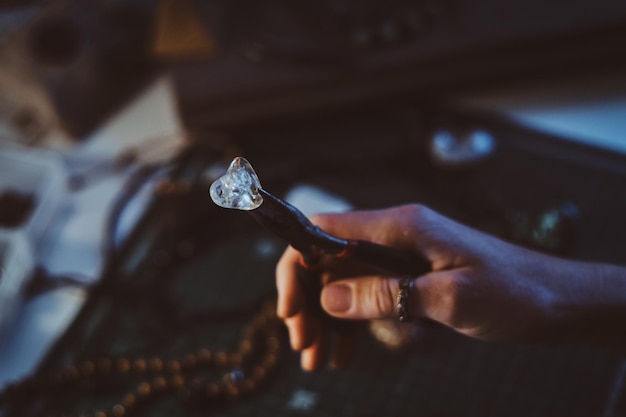 Free photo creative woman is holding pliers and crystal clear quartz in it.