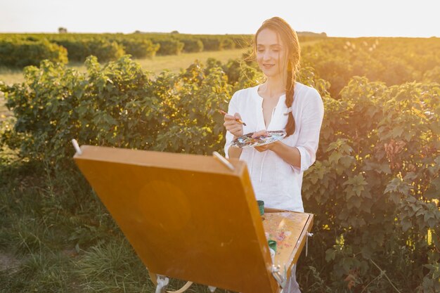 Creative woman painting in the nature