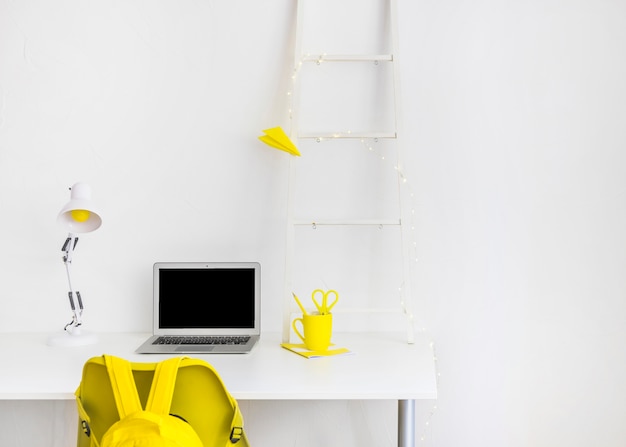 Free photo creative workspace in white and yellow colors with laptop