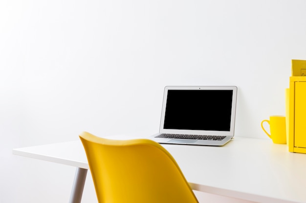 Free photo creative workspace with yellow chair and box