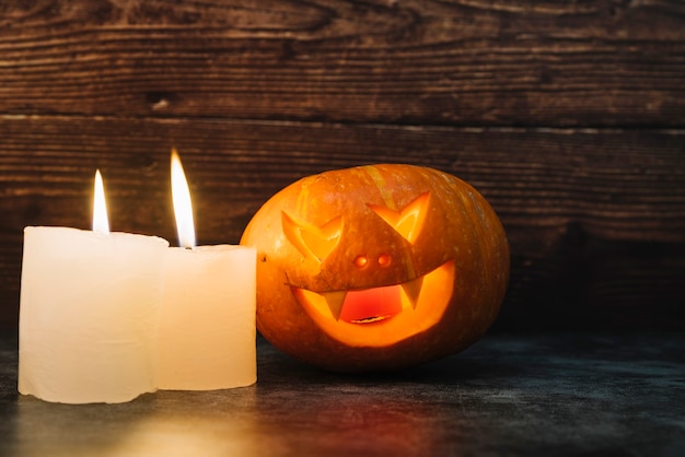 Free Photo creepy illuminating halloween pumpkin and candles