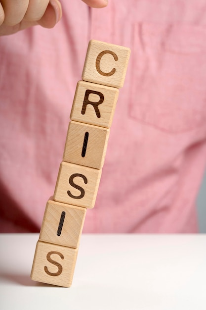 Free photo crisis message on wooden blocks falling off