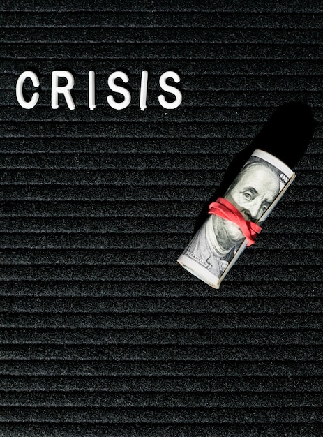 Crisis word and bank-notes with rubber band