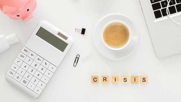 Crisis word made with wooden cubes next to financial elements