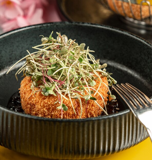 Crispy chicken nugget garnished with fresh herbs