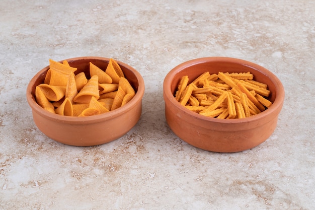 Crispy cone chips and crouton in bowls, on the marble table. 