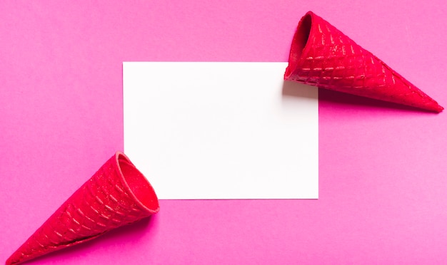 Crispy ice cream cones and white sheet on pink background