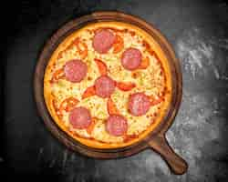 Free photo crispy pizza with cheese tomatoes and sausage