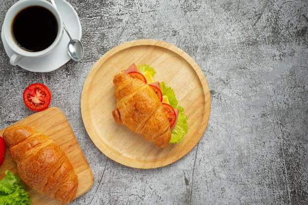 Croissant sandwiches on dark wooden surface