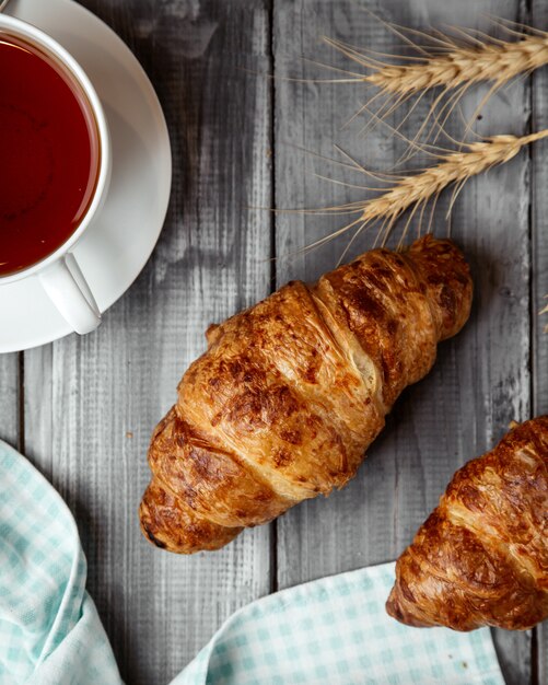 croissant with cup of tea on table