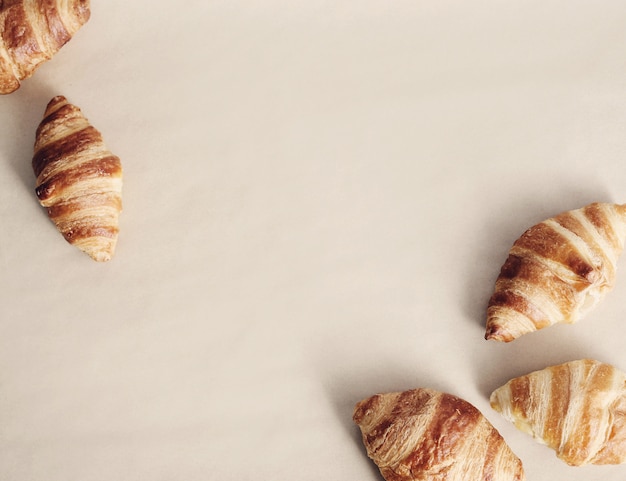 Croissants on beige background, copyspace top view