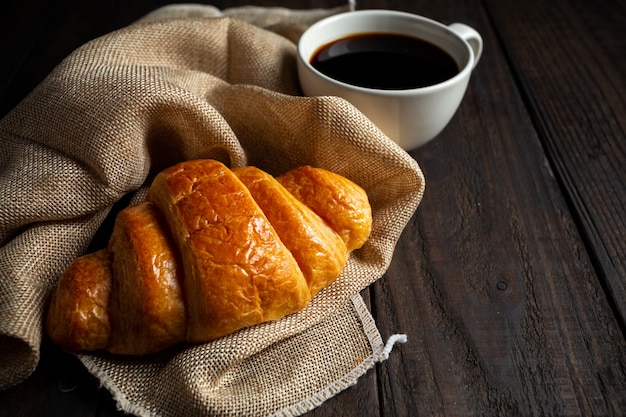 croissants and coffee on old wood table.