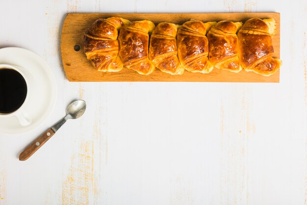 Croissants near coffee and spoon