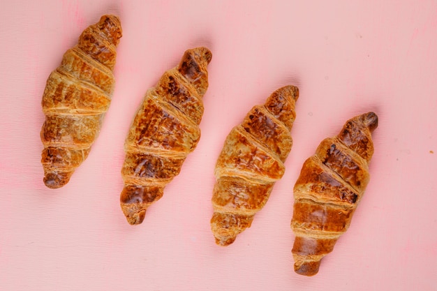 Free photo croissants on a pink table. flat lay.