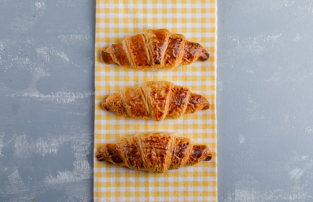 Free photo croissants on plaster and kitchen towel. flat lay.