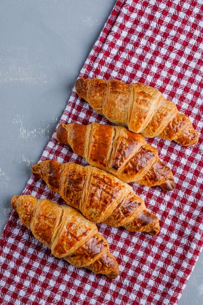 Croissants on plaster and picnic cloth. flat lay.