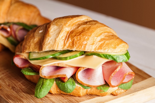 Croissants sandwiches on the wooden cutting board